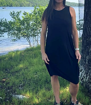 Raise Your Flagpole: A Woman in a Black Dress Poses by a Tree'