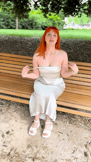 Quick Reveal in the Park: A Woman in a White Dress Exposes Her Breast'