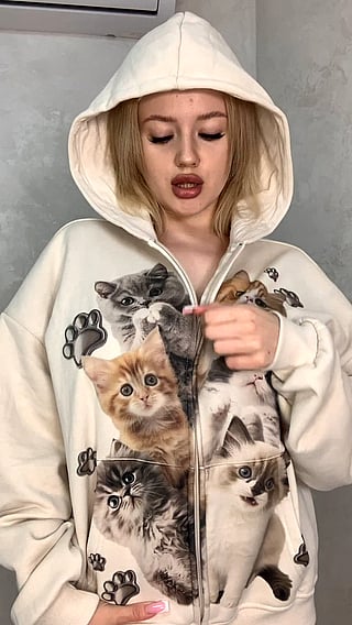 Big Tits or Big Personality? A Woman in a Cat Sweater Shows Off Her Chest'
