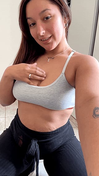 Gym Top or No? Woman Shows Off Her Bare Chest in a Gray Tank Top'