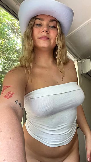 Letting Them Jiggle: A Woman in a White Tank Top Shows Off Her Breasts'